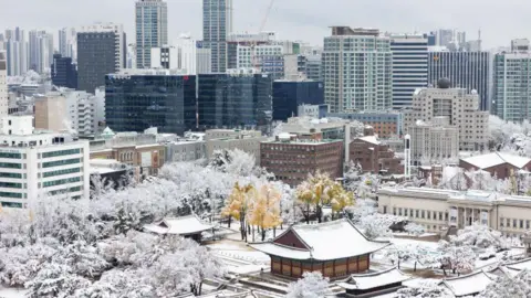 Bloomberg via Getty Images Commercial buildings during the first snow of the season in Seoul