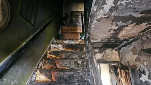 Lola Ebury Fire damage to the stairs and the ceiling of the house.