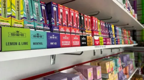 Shelf of different flavoured vapes