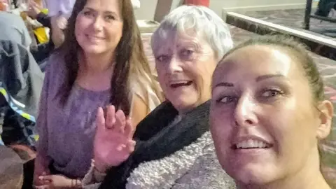 Denise Scott Denise Scott front of the image with her mother behind her and her sister behind her.