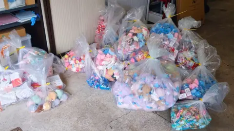 North Yorkshire Council Large transparent plastic bags filled with assorted small toys and plush items.