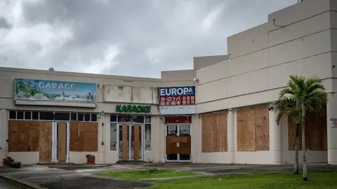 Stores boarded up with plywood are seen as the forecasted Super Typhoon Bavi approaches in Guam