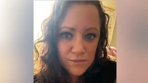 A close-up picture of Amanda's face. She is wearing a red and white striped top, beneath a darker top.