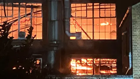 Flames are rising from a disused factory building.