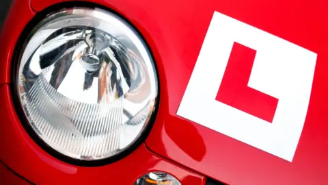 Getty Images A red car with an L plate sticker on front bonnet to indicate the car is being driven by a learner driver