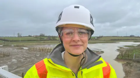 A woman in hard hat and high vis clothing 