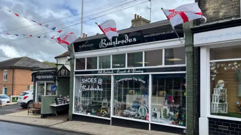 Darren Rozier/BBC A shopfront with Bulstrodes written on it and three England flags