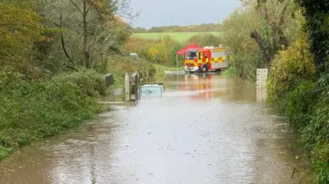 Fire truck by car submerged in water