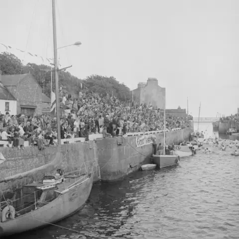 MANX NATIONAL HERITAGE A black and white photos of large crowd of people on a grandstand overlooking the harbour.