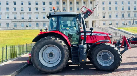 A red tractor sits at the front of Parliament Buildings at Stormont. 