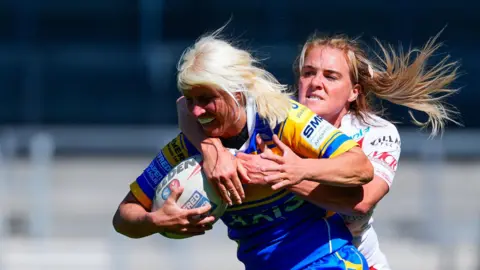 Jenna Greening of Leeds is tackled by Amy Hardcastle of St Helens