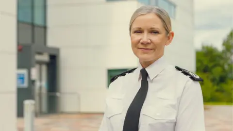 Cleveland Police Victoria Fuller has slicked back blonde hair and is wearing a white shirt and a black tie.