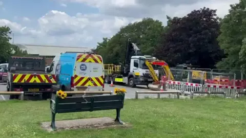 Southern Water vans in a car park with tankers and workmen dressed in orange.