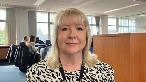 A woman in a patterned top sitting in an office