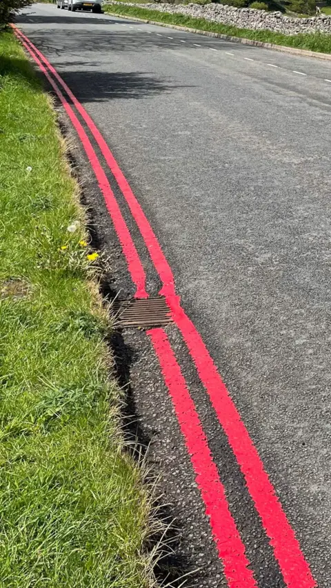 Double red lines painted on a road in the Peak District