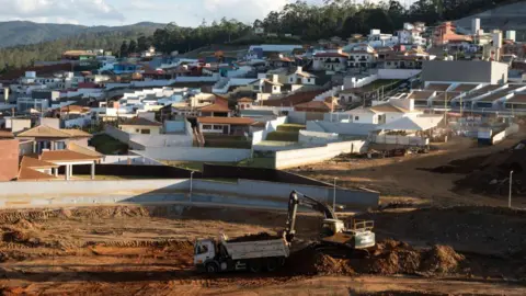 Getty Images Bouwwerkzaamheden in Novo Bento Rodrigues, een hoogwaardige hervestiging gebouwd voor de voormalige bewoners van Bento Rodrigues, tijdens een wandeling rond de plaatsen die getroffen zijn door de 'Mariana Dam Disaster' op 1 mei 2024 in Mariana, Brazilië