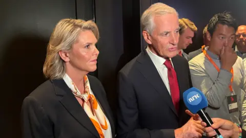 News Room : Tight vote in Norway to decide whether to stick with Labour or turn right 1 BBC/Alex Maxia A man and woman, both political leaders, stand behind a microphone in front of a dark wooden panelled wall