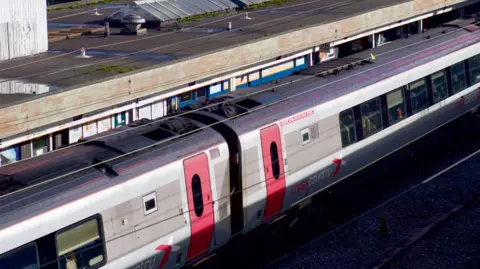 A silver and red crosscountry train pulled up at a platform at Wolverhampton train station