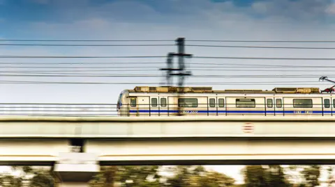 A speeding New Delhi Metro Train running on its elevated track.