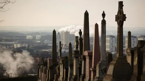 A row of graves at the Necropolis cemetery, which is on top of a hill, with the city lying behind and below