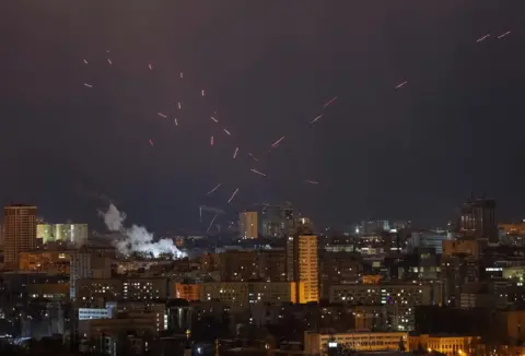 Gleb Garanich/Reuters Tracers terlihat di langit malam di atas Kyiv, Ukraina.