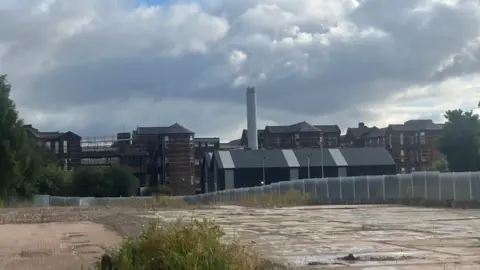 North Manchester General Hospital. The image shows the Victorian Hospital in the background, with empty land in the foreground.