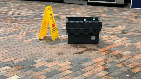 Toby Wood Buckets collecting rain water at bus station 