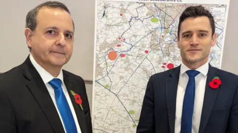 Alberto Costa Two men in suits in jackets and ties