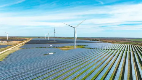 Getty Images Painéis solares e turbinas eólicas mostradas em uma paisagem