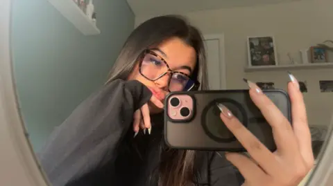 Lily Brown Selfie of Lily Brown holding camera.