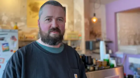 Roy Jones stands inside his cafe