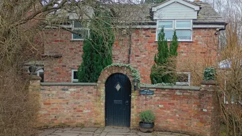 BBC The front entrance of red brick Clover Cottage where Spiby lived and made drugs