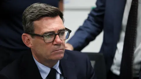 Reuters Andy Burnham wearing a serious expression in a suit and tie at a visit to HM Coastguard Maritime Rescue Coordination Centre, in Dover