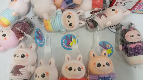 Gloucestershire County Council Squishy toys with faces are pictured lying on a white table.