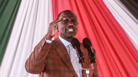 Kenyas President William Ruto gesticulates with his hands while he speaks into a microphone on stage at an interdenominational prayer service at Nakuru Athletic Club two years ago.