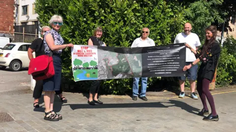 Campaigners against housing development holding a banner