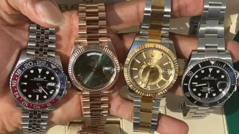 Nottinghamshire Police Davante James holds four watches in his left hand