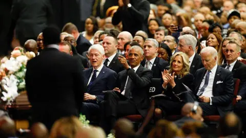 Getty Images Seated in a packed memorial service, left to right are former US president Bill Clinton, former president Barack Obama, former first lay Jill Biden and former president Joe Biden.
