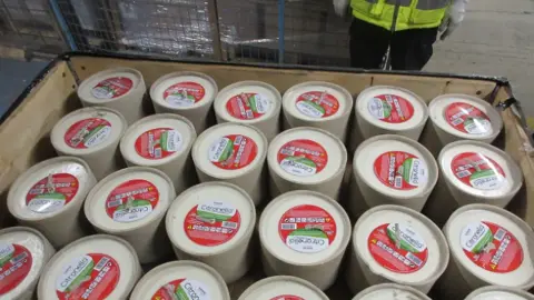 Merseyside Police Rows of Citronella candles, with red labels, in which the cannabis was hidden