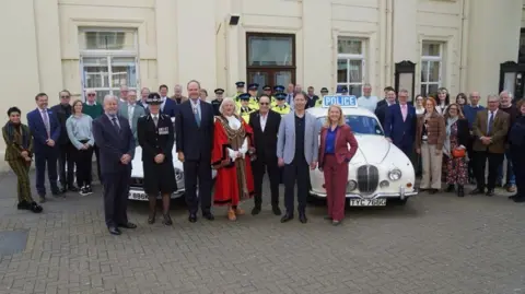 Dignitaries stood in front of vintage police cars outside the Old Police Cells Museum, in Brighton