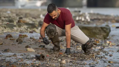 London Museum Mudlark Alessio Checconi examines the Thames foreshore 