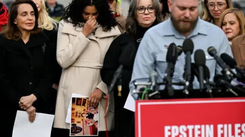 Survivors Lisa Phillips, Jess Michaels, and Annie Farmer look sad as as Sky Roberts, brother of late sex offender Jeffrey Epstein's late victim Virginia Giuffre, speaks during a press conference