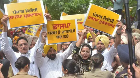Getty Images Punjab Cabinet Minister Harbhajan Singh ETO, AAP MLAs with party workers staging protest outside residence of BJP national general secretary and Rajya Sabha member Tarun Chugh for the BJP allegedly playing politics over the Akal Takht verdict against CM Bhagwant Mann, on June 20, 2026, in Amritsar, India.