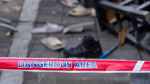  Scorched debris and charred remnants litter the exterior grounds of the Lat Phrao entertainment venue