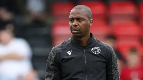 Darren Byfield takes a pre-match warm-up as first team coach at Walsall