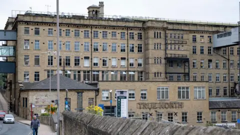 Getty Images A view of Dean Clough, a former mill which has seen been created into a space for commercial and cultural use. The stone building is several stories high and features multiple sections.