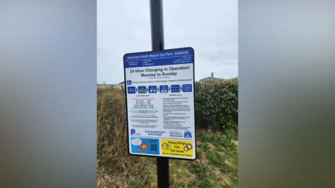 Nicky Bailey View of a parking sign at Heacham beach showing the charges for different vehicles and time scales.