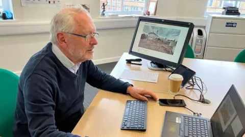 Labour City Mayor Sir Peter Soulsby sits at a laptop in his office