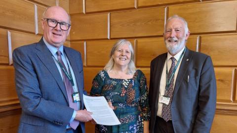 Cath Cottingham and councillor Jeremy Yabsley (right) present the bus petition to councillor James McInnes