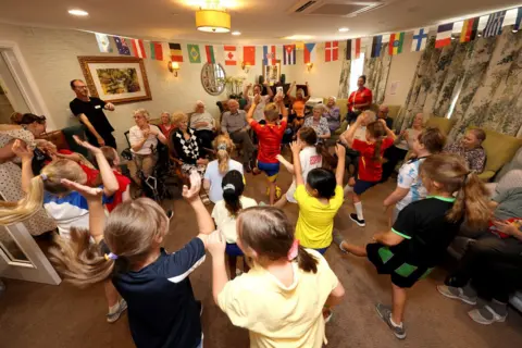 Sam Stephenson Children perform in front of the care home residents to celebrate the World Cup